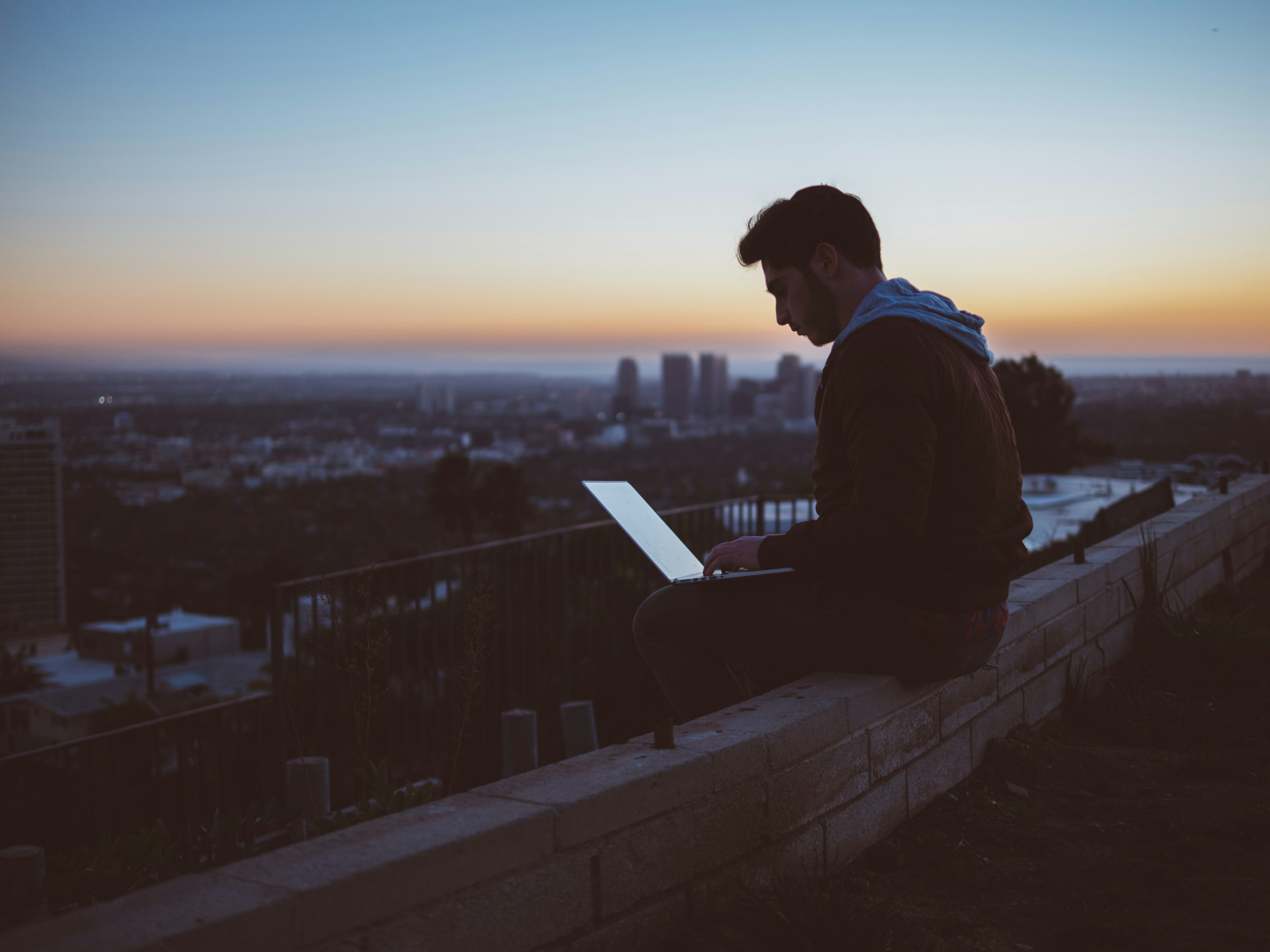 Guy looking at computer at sunset